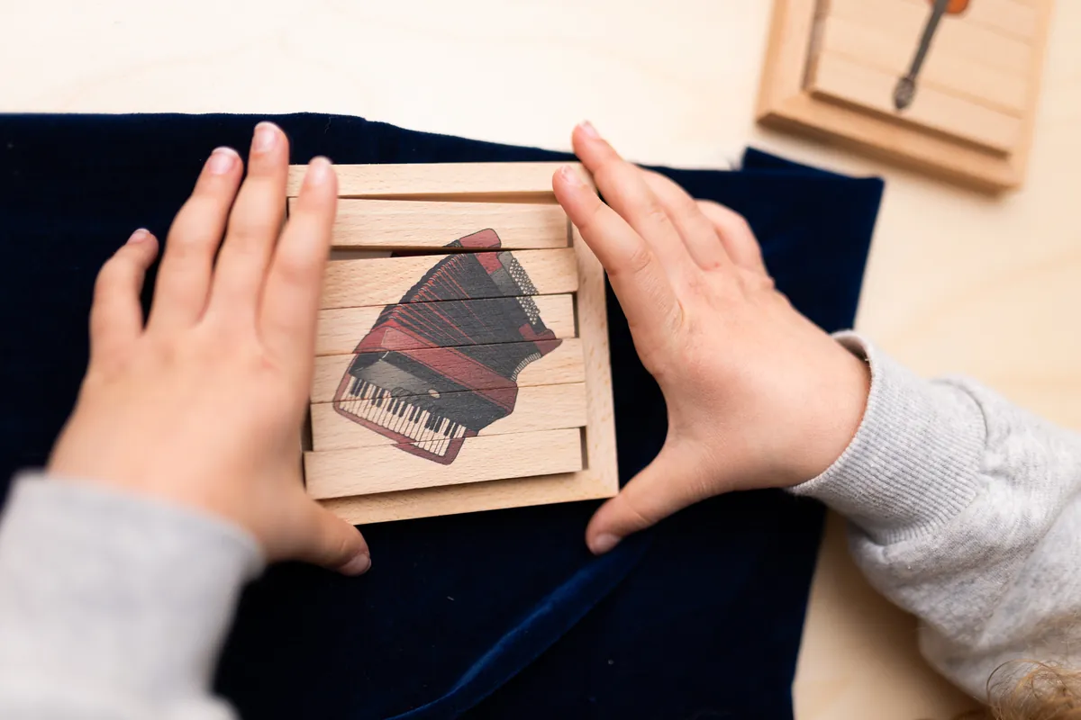 Enfant qui fait un puzzle en bois Serclet